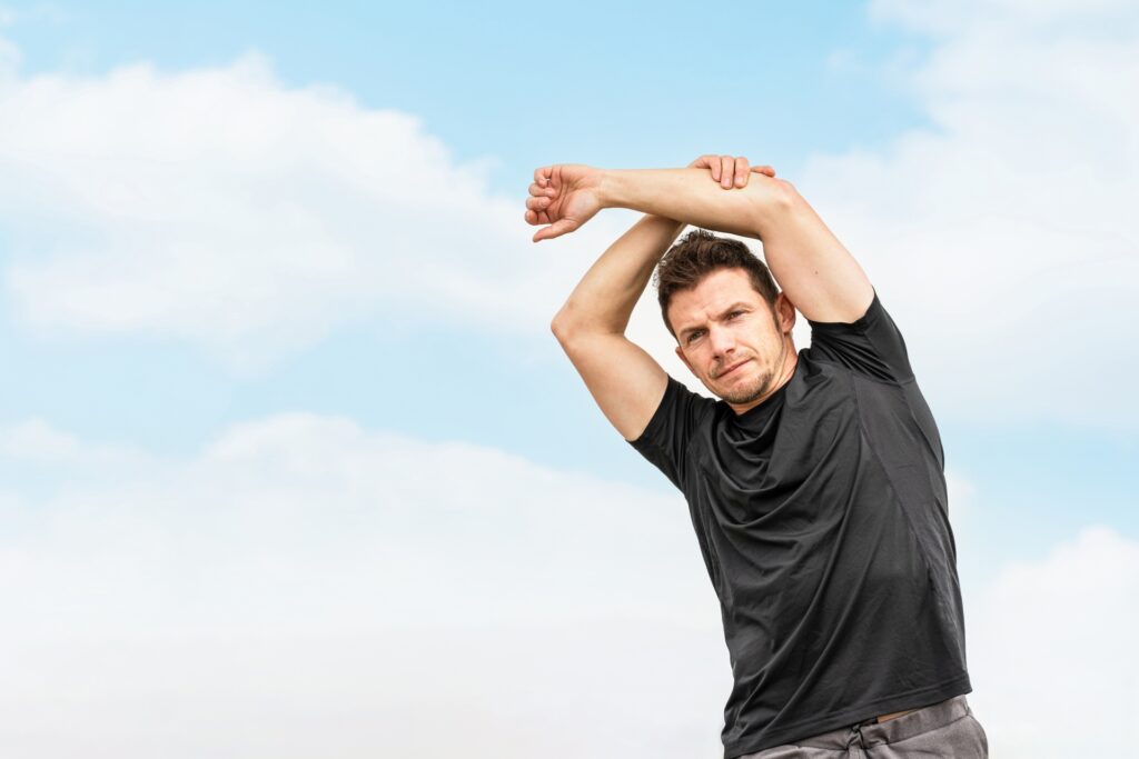 忙しい日常の中でも体を整えるためにストレッチを行う40代男性。無理なく続ける筋トレ習慣を象徴する一枚。