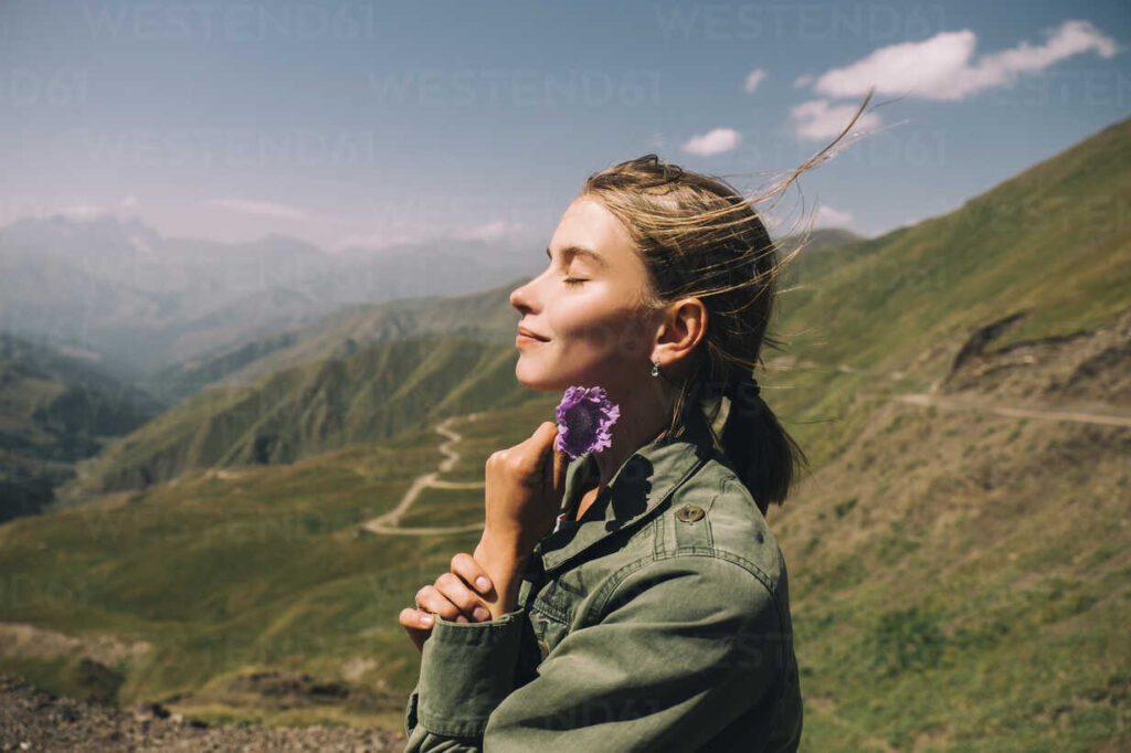 朝日の光を浴びながら目を閉じて微笑む女性。恋愛アファメーションの導入イメージ。