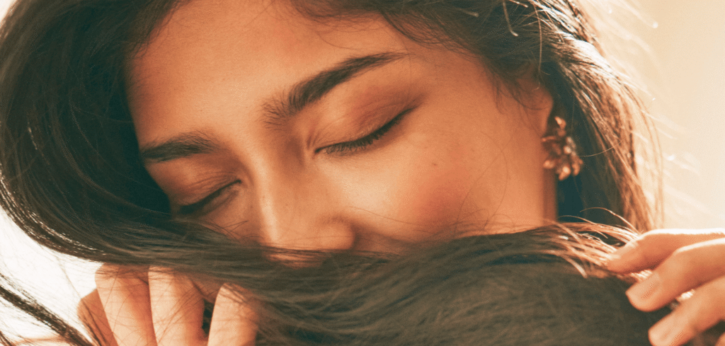 朝の柔らかな光の中で目を閉じて微笑む女性の写真。
穏やかな表情で、自分と向き合い感謝を感じている様子。