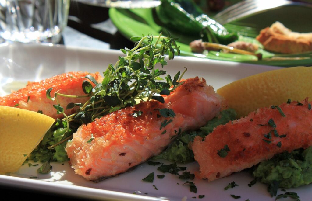 サーモンとサラダが盛られたプレートの写真。良質な脂質とビタミンを含む食事で、夜でも太りにくい食べ方をイメージしたもの。