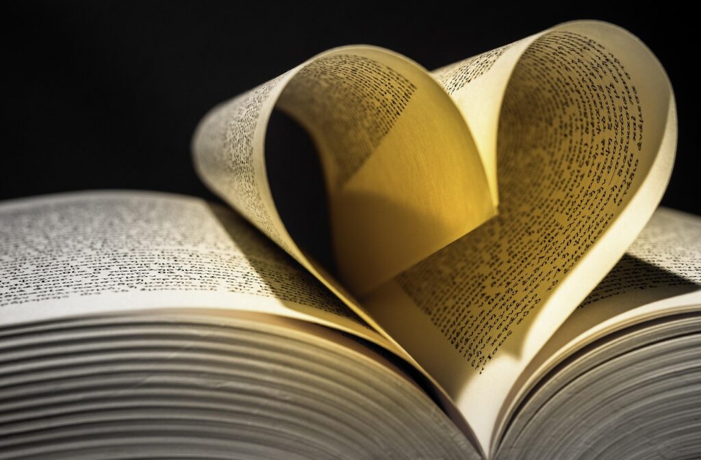ハート型に折り重なった本のページの写真。自己愛や感謝を象徴するアファメーションのイメージ。