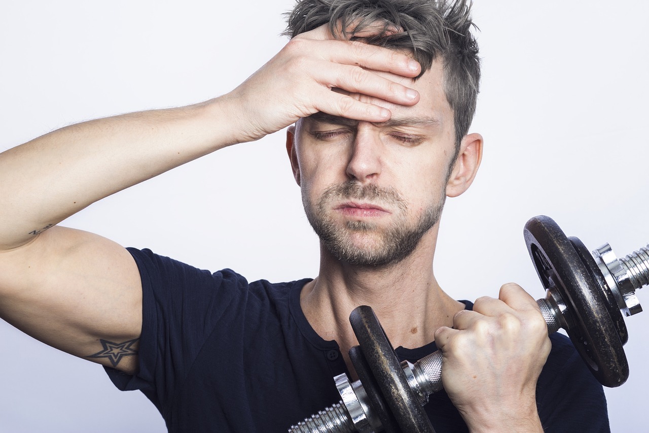 筋トレ後に疲れて眠気を感じている男性のイメージ