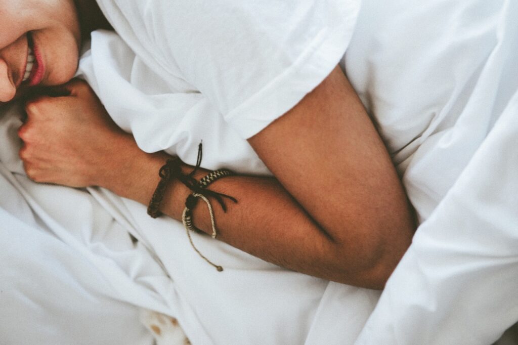 ベッドの上で横になり、穏やかな表情で過ごす女性。何気ない時間を大切にする様子