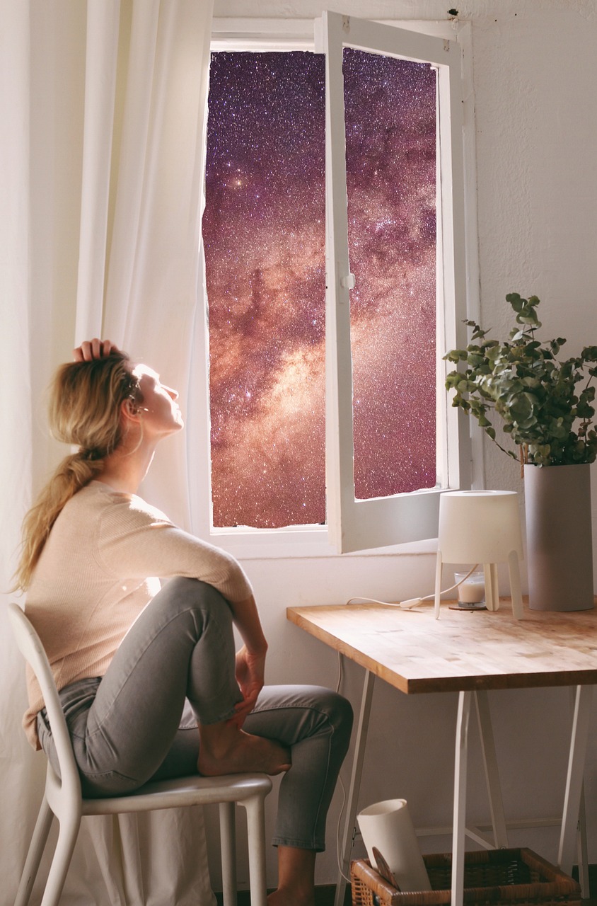 出窓を開け、星空と天の川を静かに見つめる女性。夜のやさしい時間に心を整えている様子。