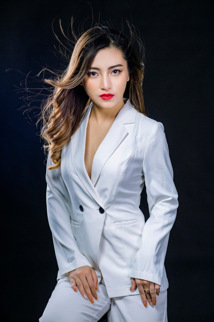 「白いスーツを着た女性が正面を向き、自信に満ちた表情でポーズを取っている。自己信頼と前向きなエネルギーを象徴するアファメーションのイメージ。」