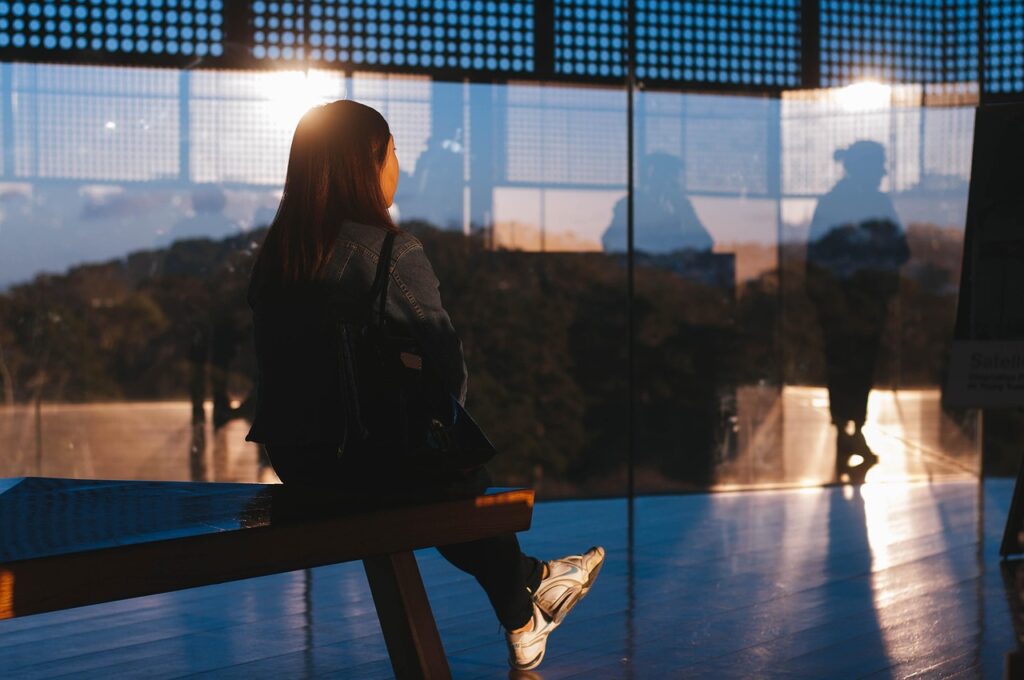 朝の光の中、ベンチに座って静かに過ごす女性。夜勤明けのひとり時間を大切にしている様子