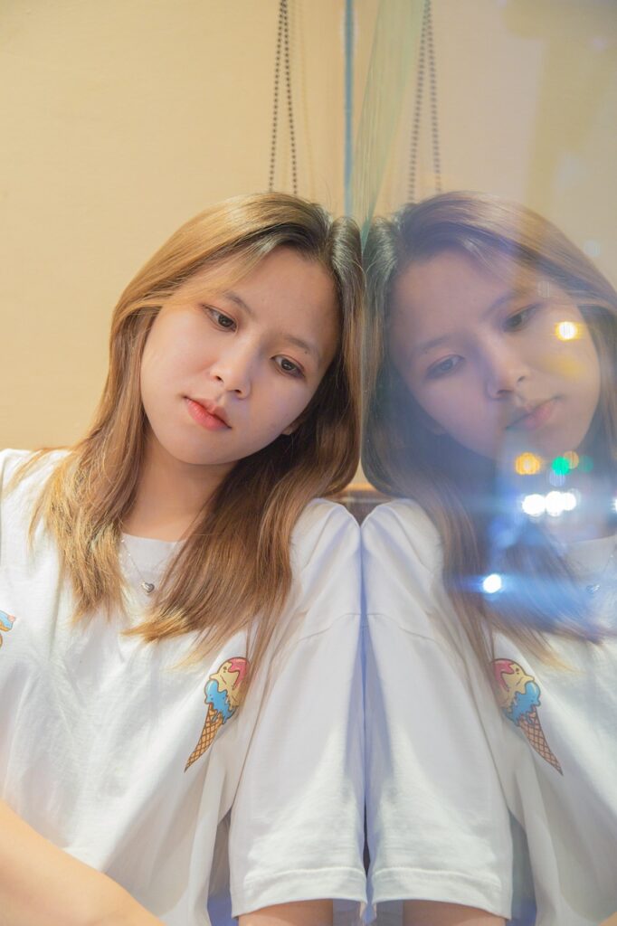 室内で鏡にもたれ、横を向く女性のポートレート