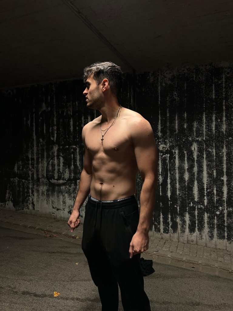 短髪の男性が上半身裸で立ち、腹筋や大胸筋、肩・腕の筋肉がはっきりと見える写真。
40代以降でも体を変えることができる筋力と健康的な体づくりの象徴となるビジュアル。