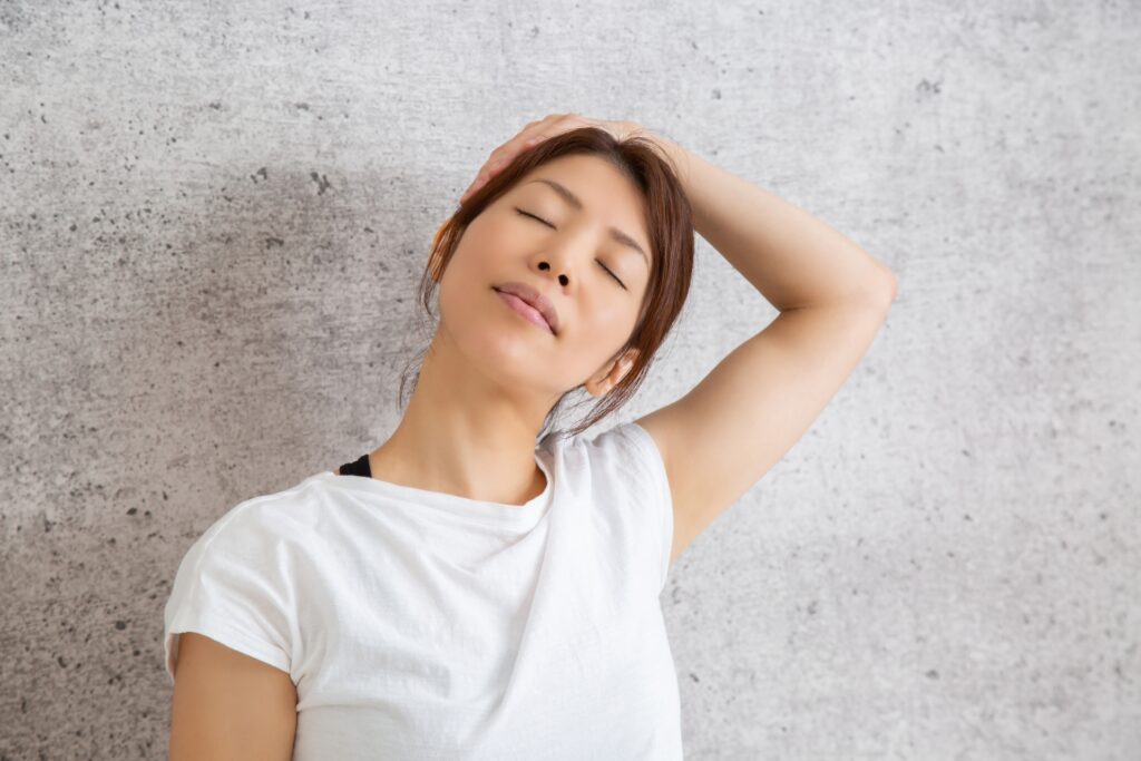 首と肩をゆっくり伸ばすストレッチをする女性