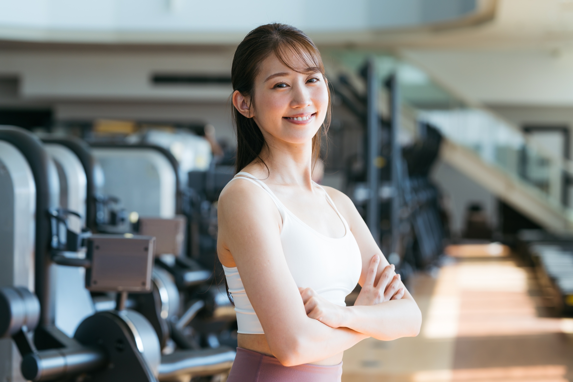 ジムで微笑む健康的な女性。運動を習慣化するイメージ写真