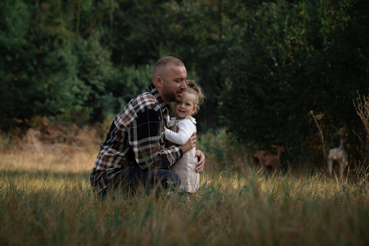父親が幼い娘を抱きしめる風景。会えない時間があっても消えない父性と愛情を象徴する写真
