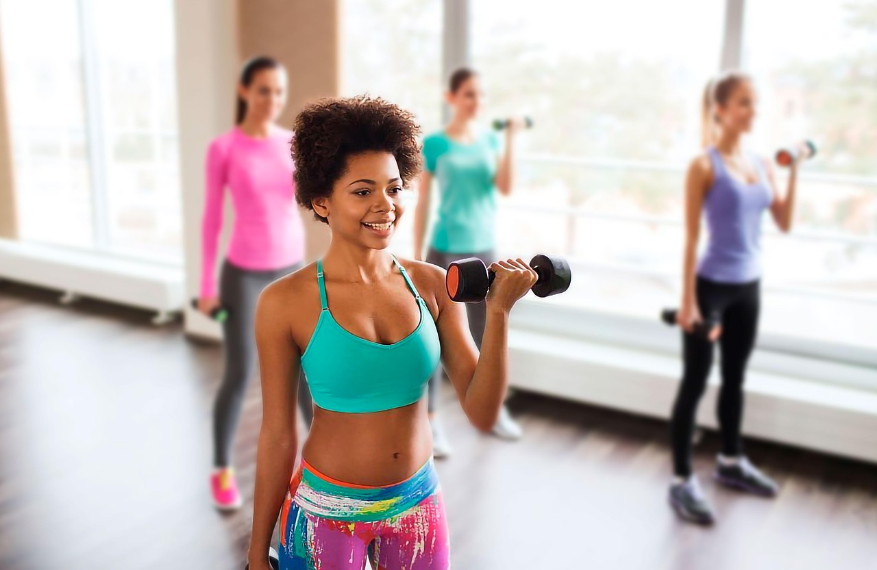 ダンベルを持って運動する女性たちのグループトレーニング