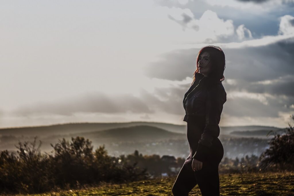 夕方の丘を一人歩く40代女性の後ろ姿｜将来に迷いながらも前に進もうとする様子