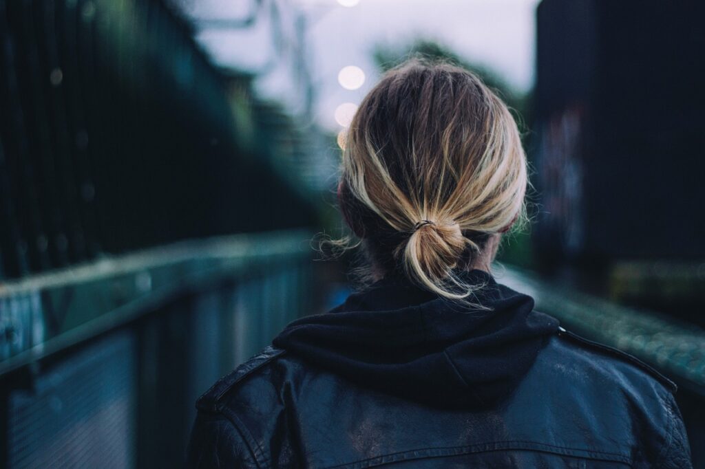 暗い道を一人で歩く後ろ姿の女性。願うだけで立ち止まっていた心の状態を象徴するイメージ