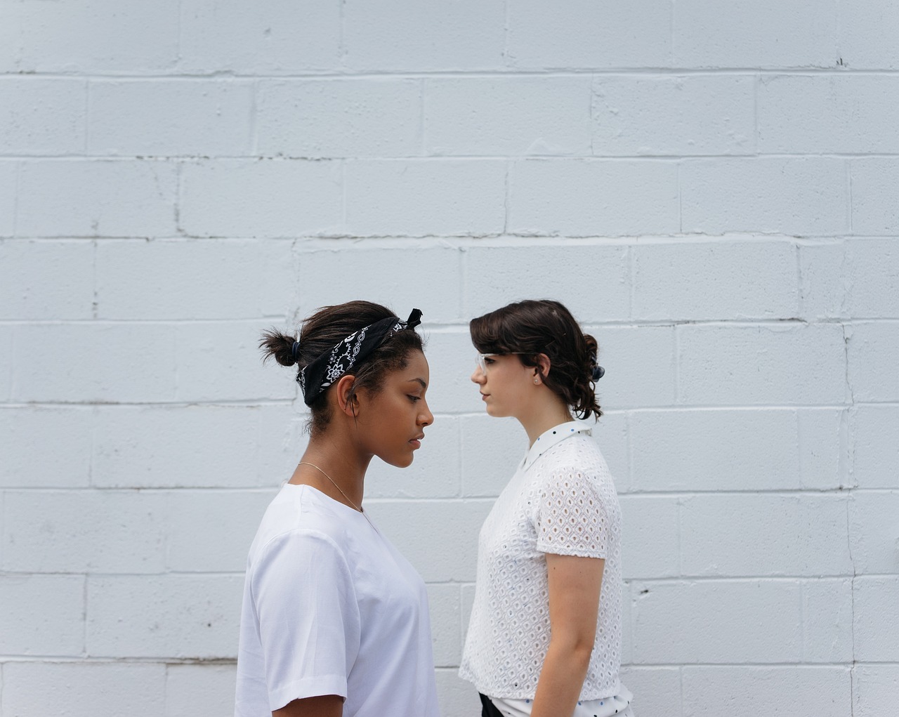 向かい合って立つ二人の女性。言葉と行動のズレ、価値観の対立を象徴するイメージ