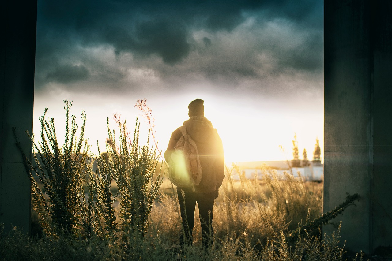 暗いトンネルの出口に立ち、差し込む光を見つめる人物。40代で人生が一度止まっても、再び歩き出せることを象徴する風景。