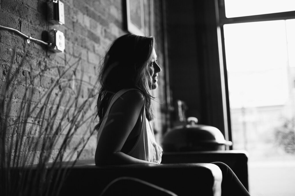 窓から差し込む光の中で、一人静かに座り自分と向き合う女性の横顔