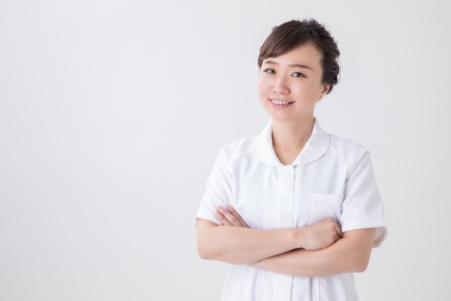 笑顔で腕を組む40代女性看護師のポートレート