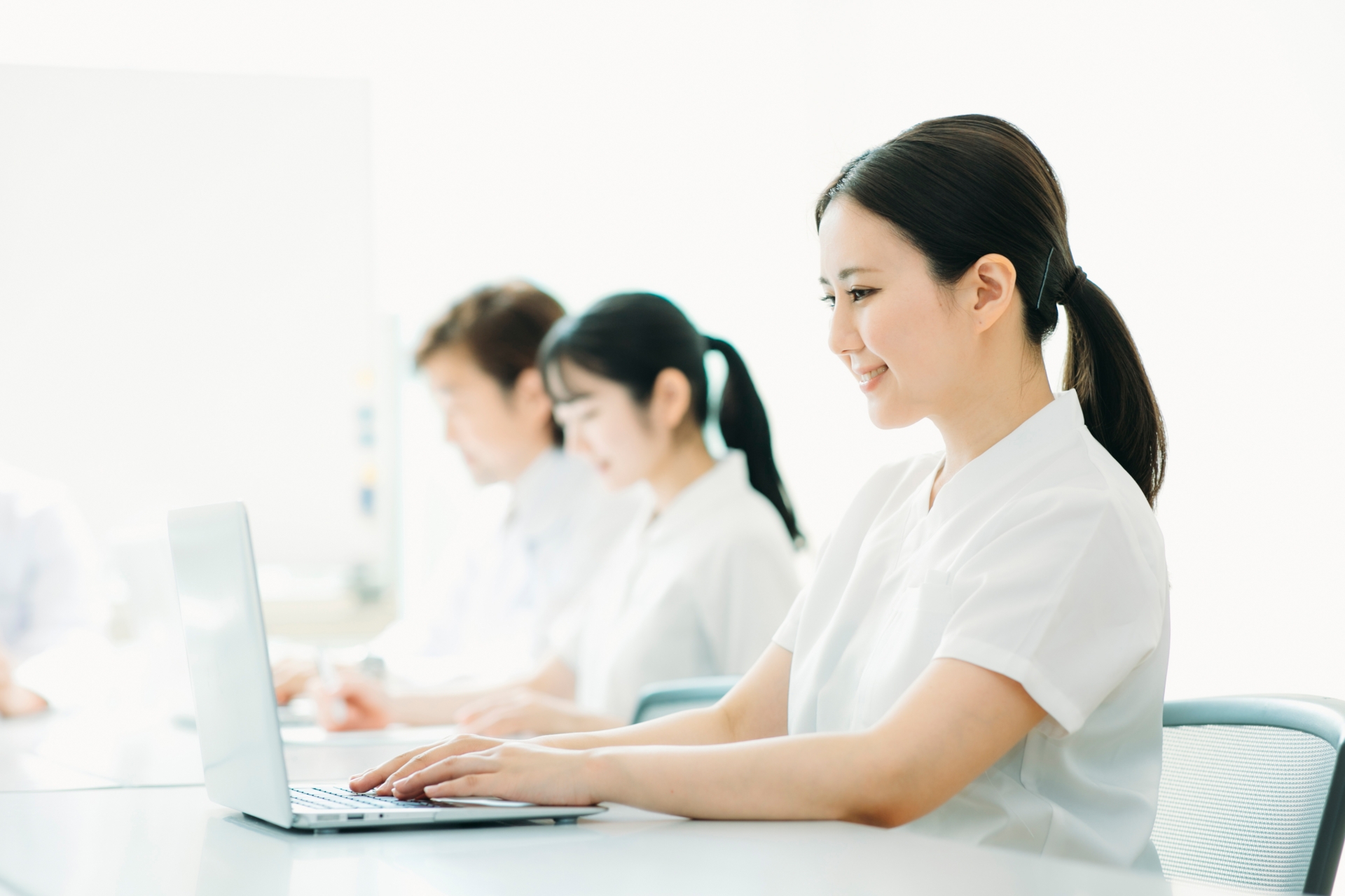 デスクでパソコンを操作する看護師の様子。制度や有給休暇について確認しているイメージ