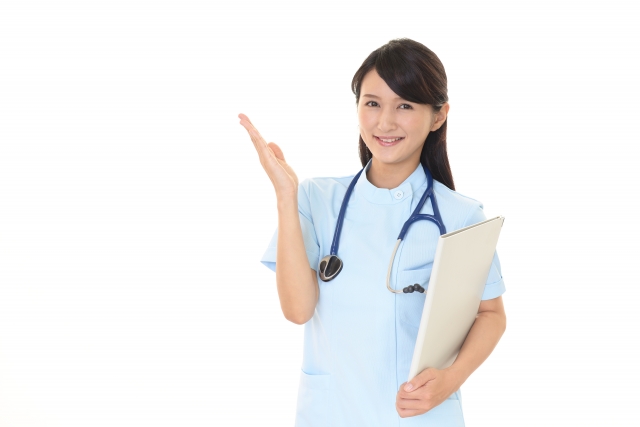 笑顔で資料を持ち案内する40代女性看護師のイメージ写真｜働き方再設計の象徴