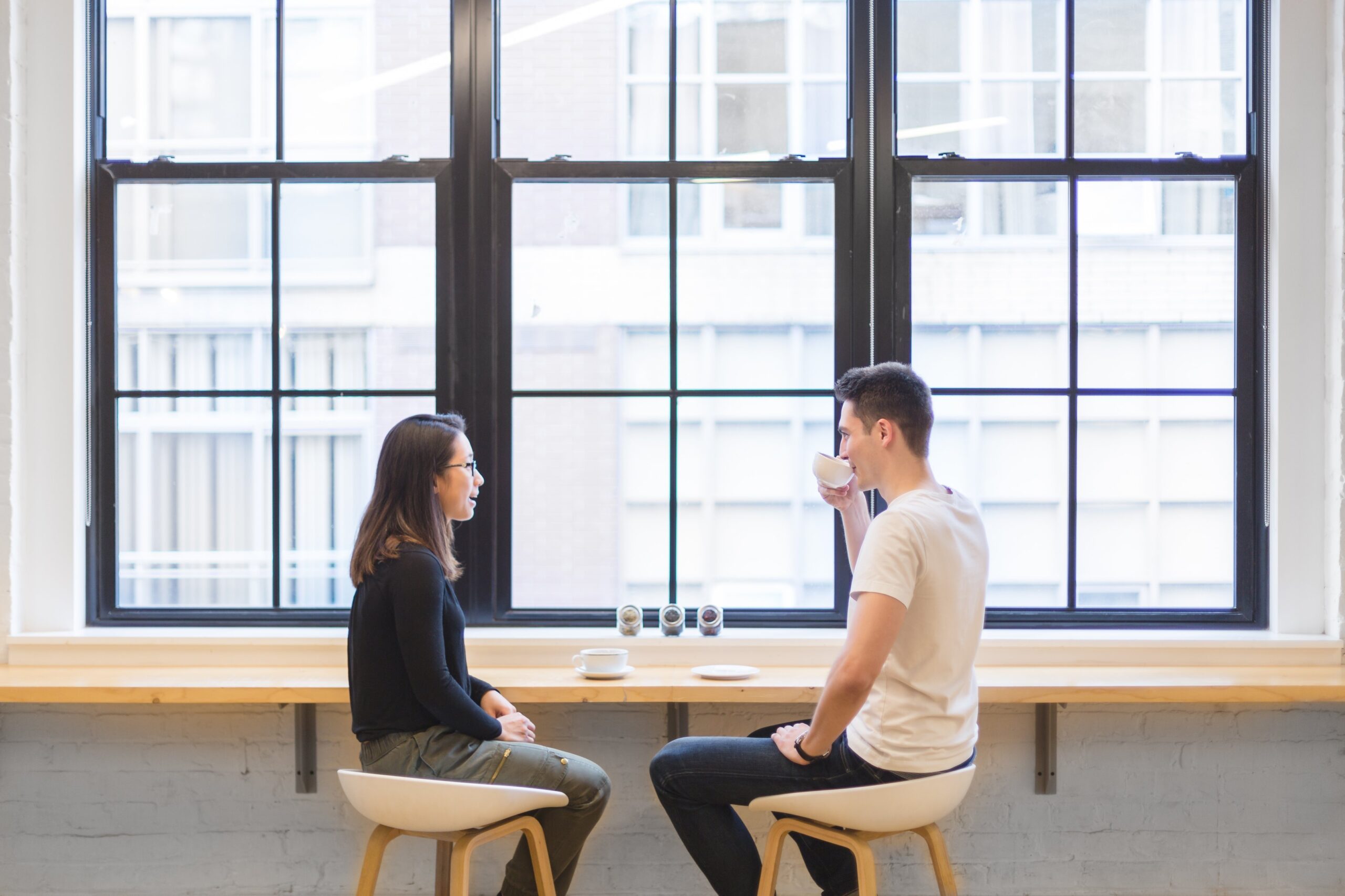 カフェで向かい合って会話をする男女。婚活中の自然な距離感をイメージした写真。